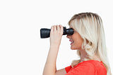 Side view of an attractive woman looking through binoculars