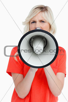 Woman looking upset while speaking into a megaphone