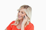 Smiling woman talking on a mobile phone while looking on the sid