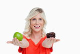 Woman holding an apple in her right hand and a muffin in her lef