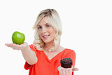 Woman looking at her favorite food between apple and muffin