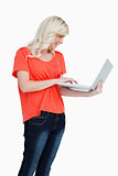 Woman standing upright while using the touchpad of her laptop