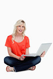 Young woman sitting cross-legged holding her laptop