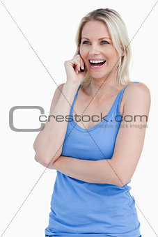 Blonde woman using a cellphone while laughing