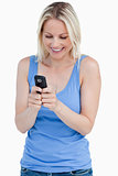 Smiling blonde woman sending a text with her cellphone