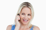 Smiling blonde woman looking on the side while on the phone