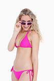 Smiling teenager in beachwear looking over her sunglasses