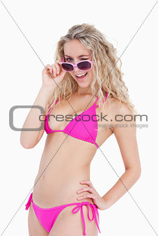 Attractive teenager looking over her sunglasses while blinking a