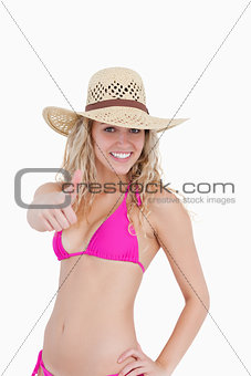 Thin teenager in beachwear showing her thumbs up