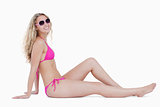Attractive young woman sitting on the floor wearing sunglasses