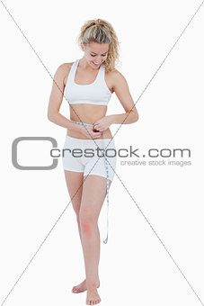 Young attractive woman measuring her waist