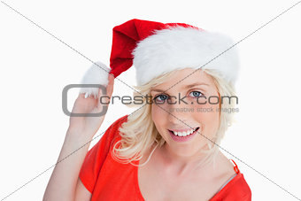 Young woman holding the pompom of her Christmas hat