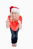 Fair-haired woman putting her thumbs up while wearing Christmas 
