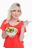 Young blonde woman eating a vegetable salad