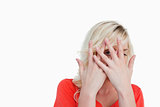 Blonde woman hiding her face behind her hands