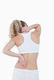 Blonde woman touching her neck and back as an indication of pain