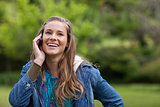Teenage girl using her mobile phone while showing a great smile