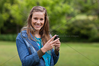 Teenage girl sending a text with her mobile phone