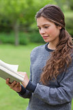 Young relaxed adult reading a book in the countryside