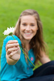 White flower held by a young smiling woman