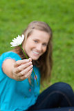 Beautiful white flower held by a young attractive girl in a park
