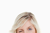 Upper part of the face of a fair-haired woman blinking an eye