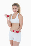 Young smiling woman lifting red weights