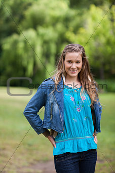 Teenage girl standing upright in the countryside