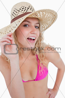 Attractive blonde teenager holding her hat brim