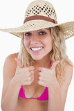 Smiling blonde teenager showing her two thumbs up
