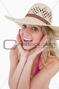 Happy young blonde woman looking at the camera with her hands on