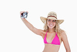 Smiling teenager photographing herself with a digital camera