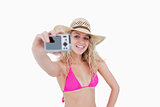 Beautiful teenage girl holding a camera while photographing hers