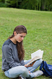 Young woman crossing her legs while reading a book