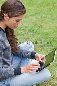 Young smiling girl sitting cross-legged while touching her table