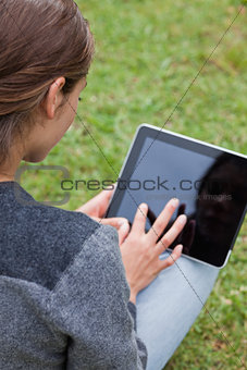 Rear view of a young girl using her tablet pc