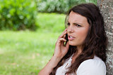 Young serious woman looking away while calling with her cellphon