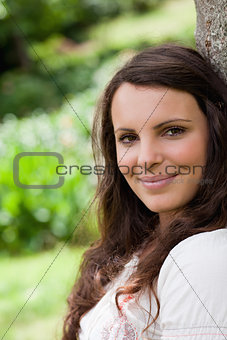 Young calm woman looking straight at the camera while leaning ag