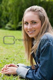 Young attractive girl looking straight at the camera while lying