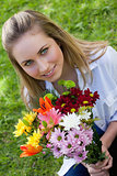 Attractive blonde teenager holding a beautiful bunch of flower