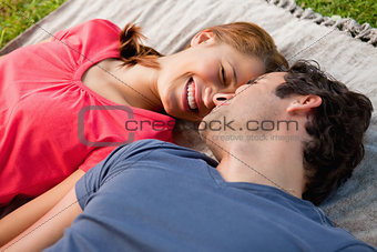 Woman smiling while lying next to her friend on a quilt