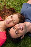Close-up of two friends smiling while lying head to shoulder