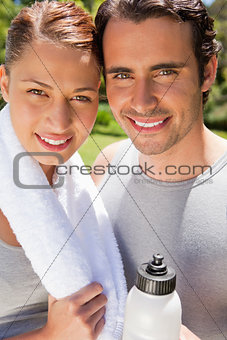 Man holding a sports bottle with a woman holding a towel