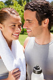 Smiling woman holding a towel while looking at a man