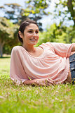 Smiling woman looking to her left while lying on her side