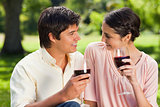 Two friends looking at each other while holding glasses of wine
