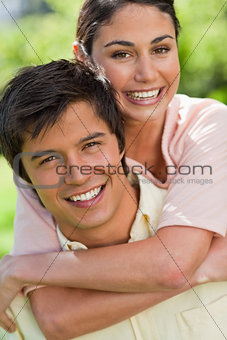 Close-up of a woman looking ahead while her friend is carrying h
