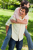 Man looking to his side while carrying his friend on his back
