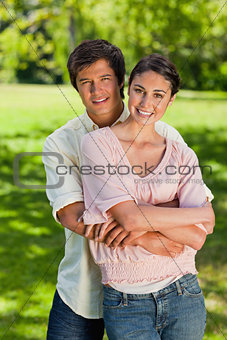 Man smiling as his he holds onto his friends waist