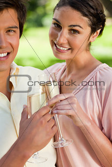 Woman smiling while touching glasses of champagne with her frien